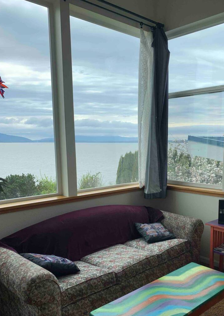 Living room with large windows offering a view of a bellingham bay, sofa, and coffee table.